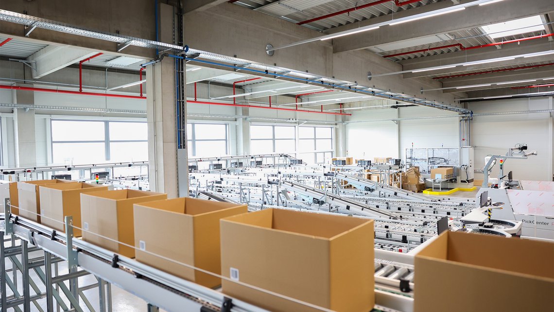 A row of cardboard boxes waiting their turn inside a warehouse